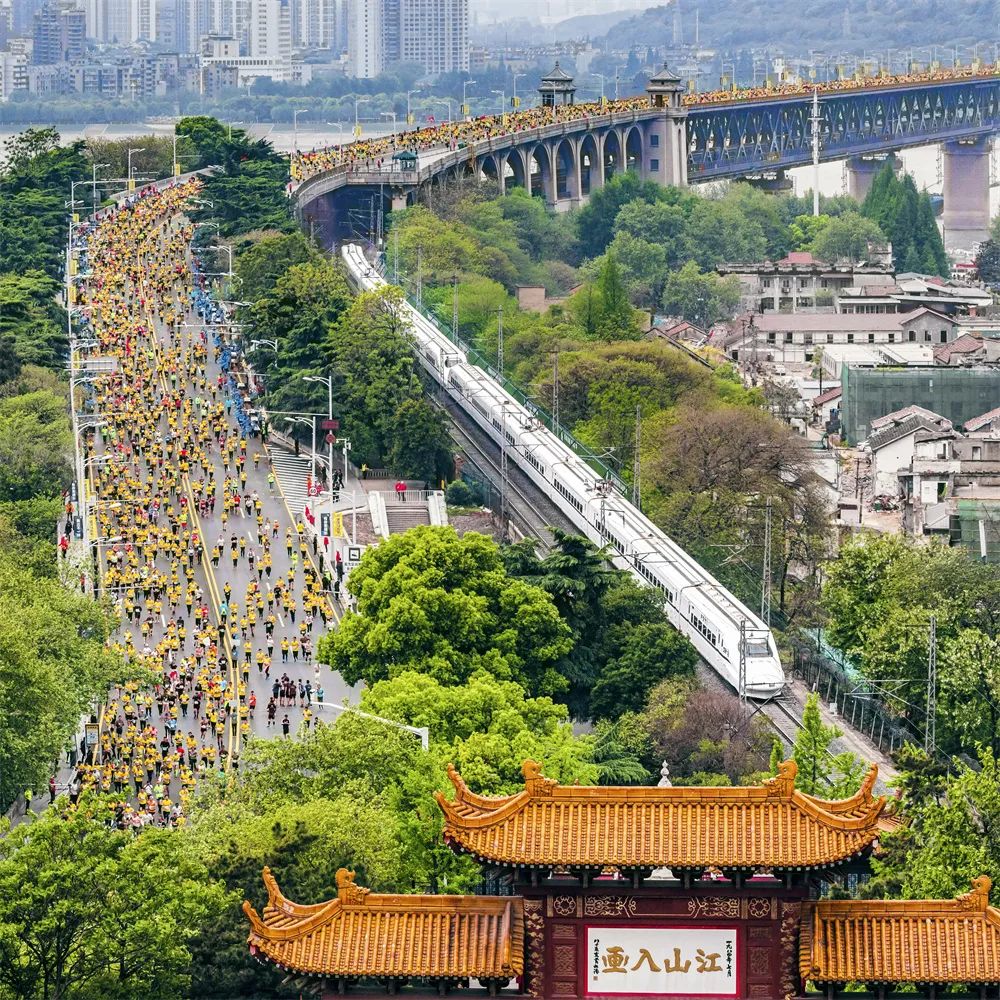 齊頭并進(jìn) 姜濤 攝2019年4月14日，參加馬拉松比賽的選手們經(jīng)過武漢長江大橋，與動(dòng)車同行，與黃鶴樓同框。.jpg