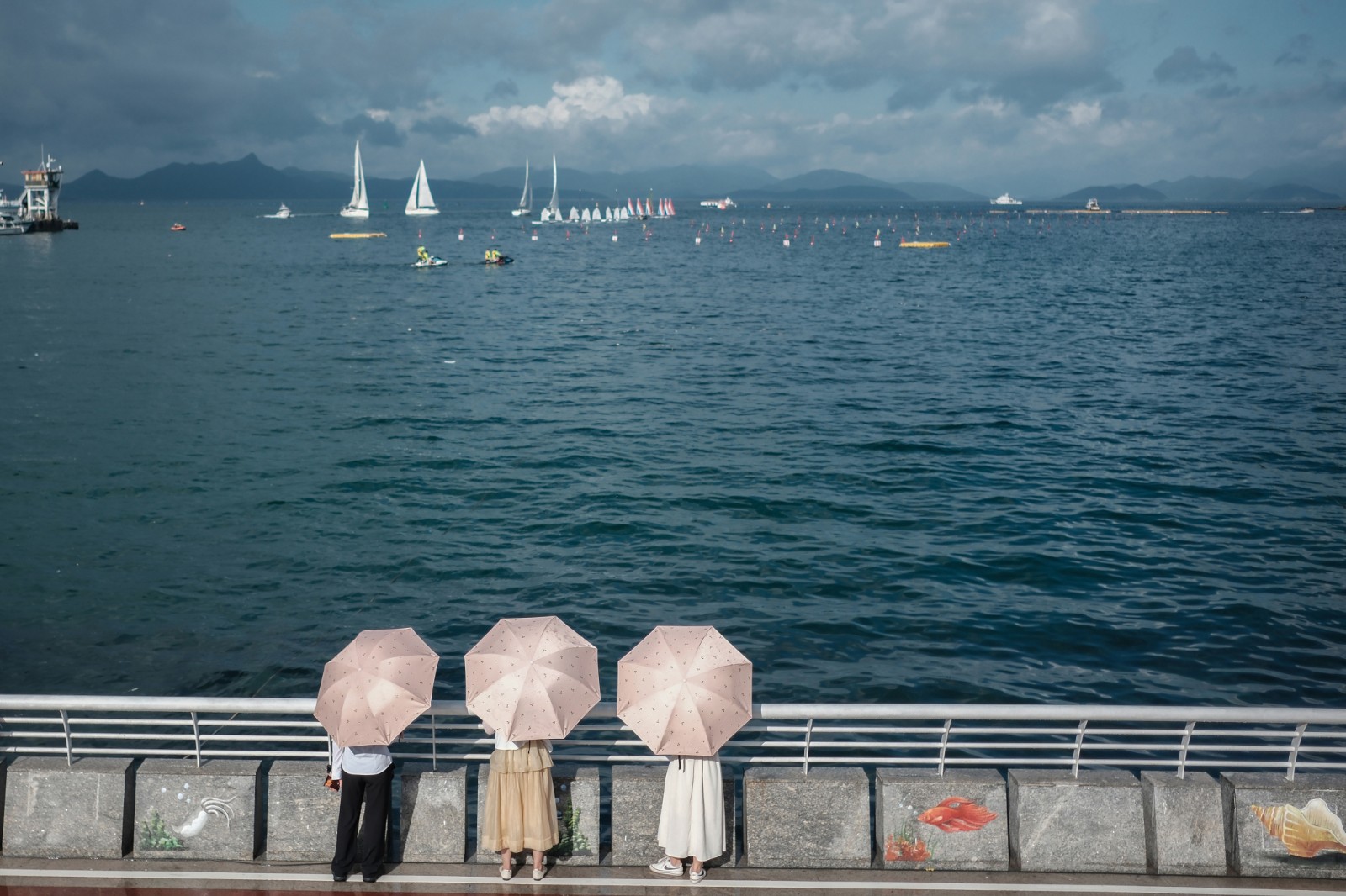 看 海-2023年6月20日，深圳南澳海邊，烈日下，游客打傘看海，遠處是在為端午舉辦龍舟賽正在進行訓練的賽手們。-薛云麾.jpg